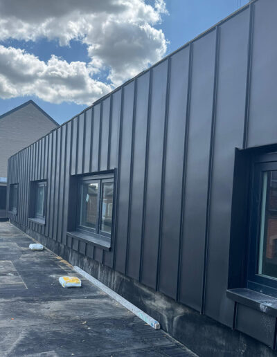 Gevelbekleding Antraciet zink gevelbekleding met vlakke panelen